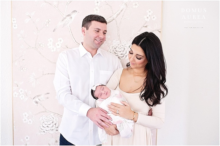 Mother and daddy shot during newborn session in front of art. 