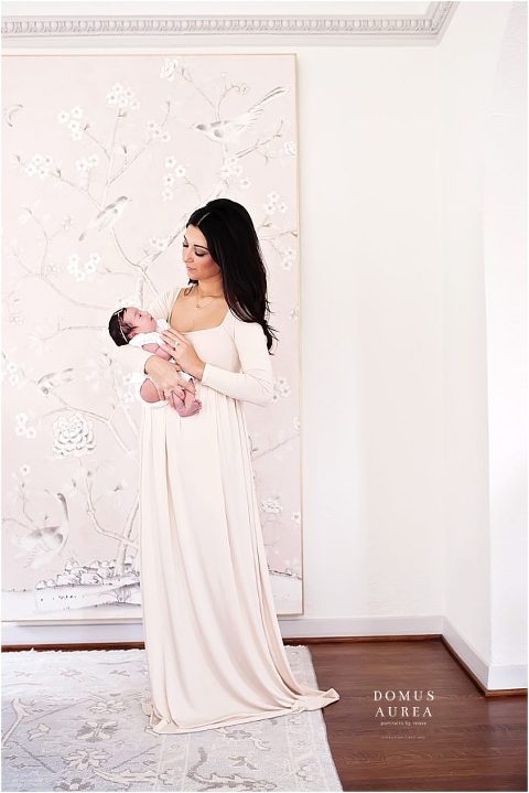 Houston newborn photographer creates a beautiful portrait of mom in light pink dress during newborn session.