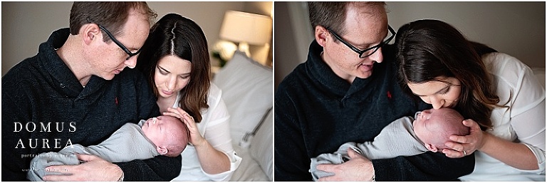 Dad and mom snuggle newborn baby.