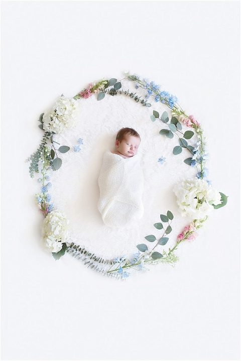 Floral wreath around newborn baby.