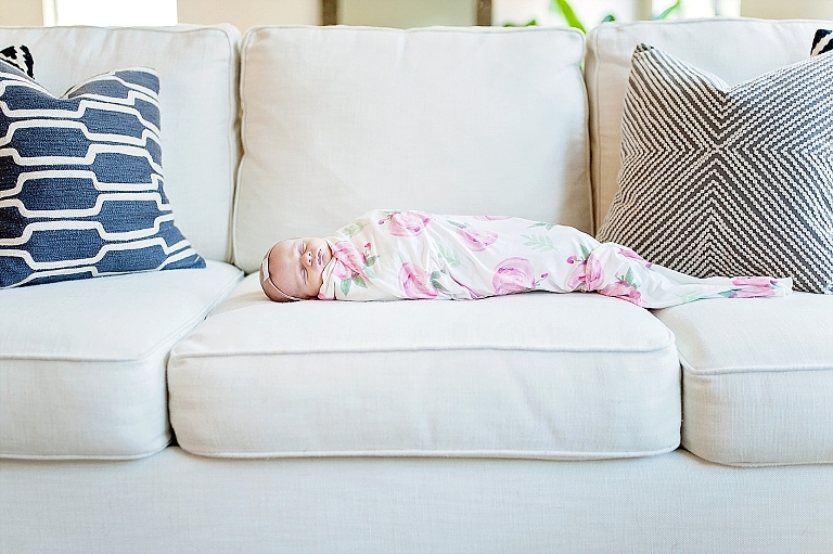 baby lays swaddled on sofa