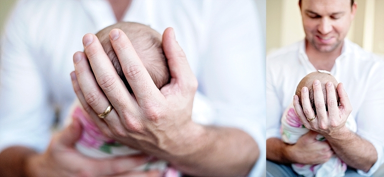 daddy holds newborn girl in his hands