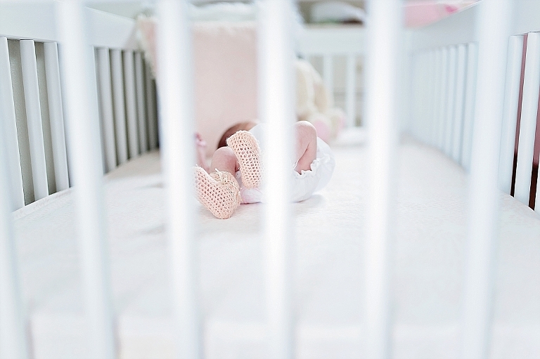 baby in crib with knitted booties