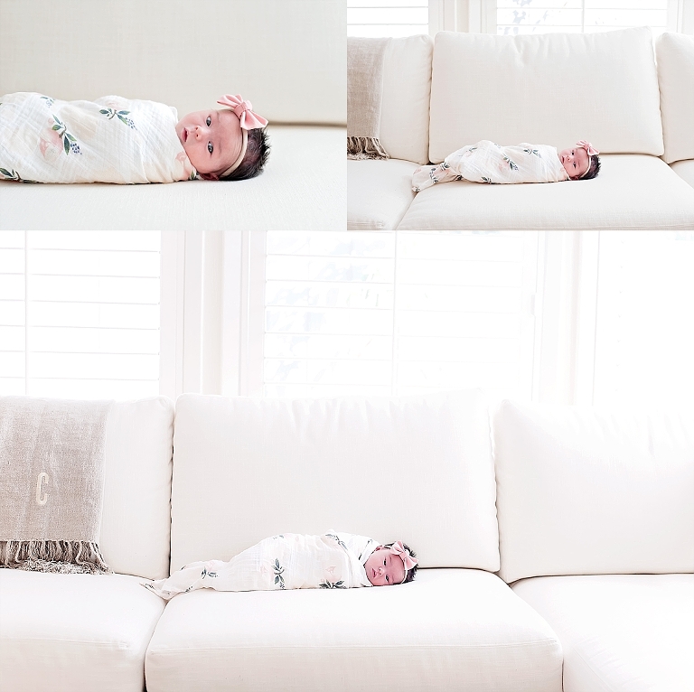 A swaddled baby girl lays on white couch during newborn session