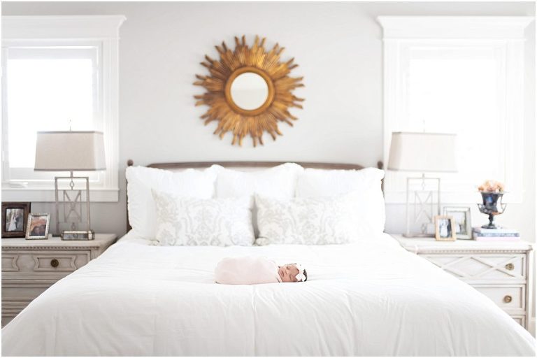 Sweet wide shot of newborn baby girl on a bed