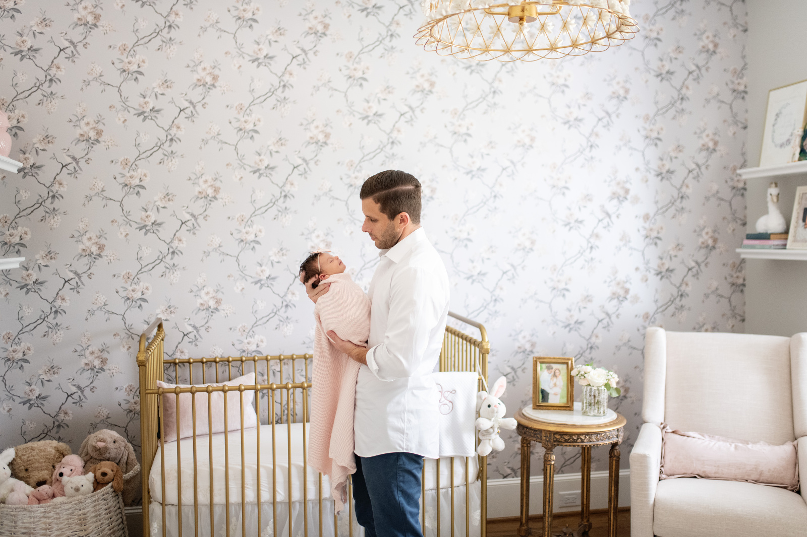 dad holds his little girl in the prettiest nursery