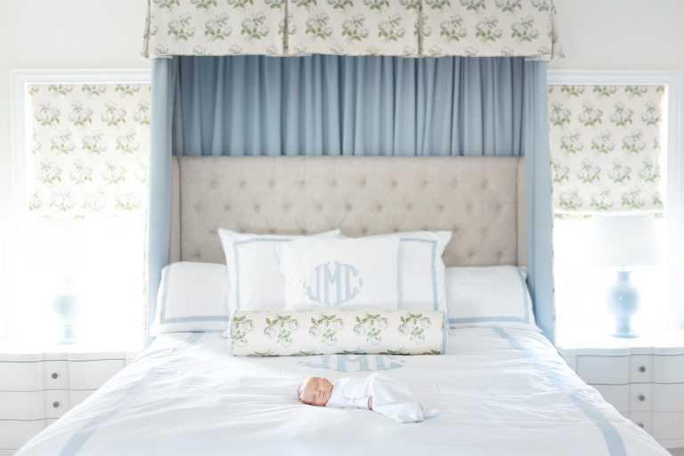 baby lays on bed in parent's master room